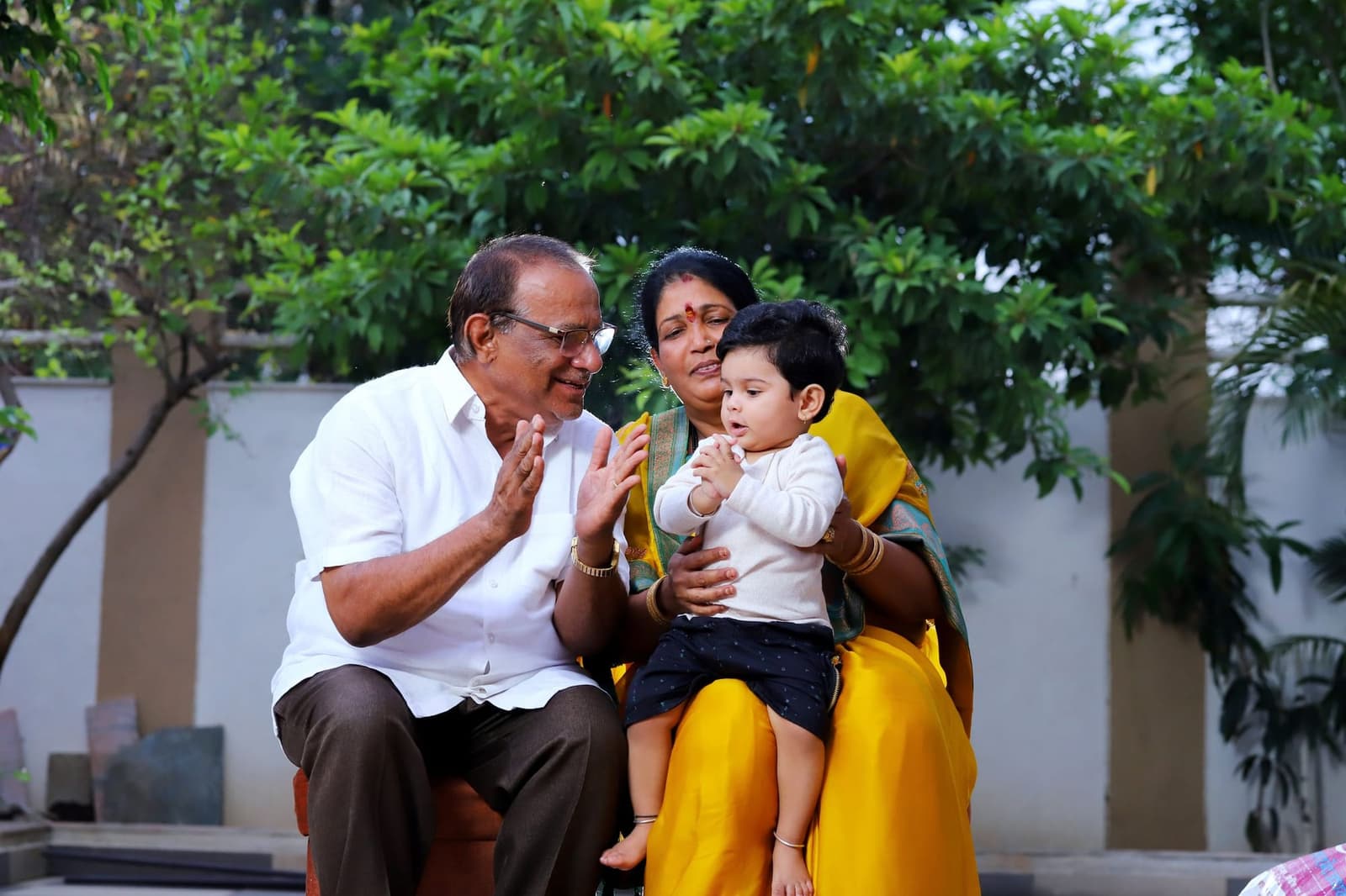 Grandparents playing with their grandson in the garden